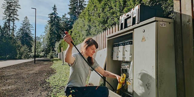Female electrical tradesperson servicing a fuse box